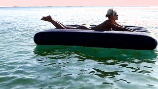 I spy on the beach as a girl with big boobs sunbathes in front of the public and dolphins