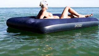 Curious Beach Day: Watch as a Stunning Blonde Enjoys the Sun with Dolphins Nearby!